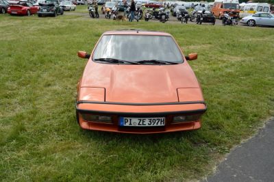 Front view of vintage sports vehicle with pop-up headlights and angular body.