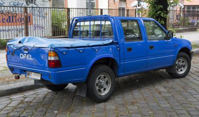 Blue double cab pickup with covered bed and rear protection bars