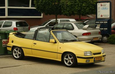 Yellow convertible with folded roof and sporty alloy wheels