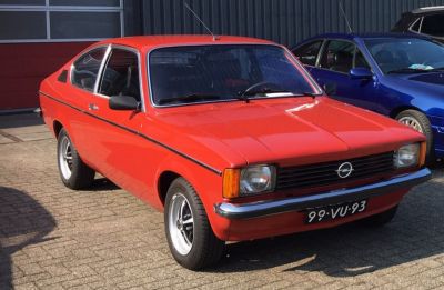 Vintage coupe with squared headlights and alloy wheels in red