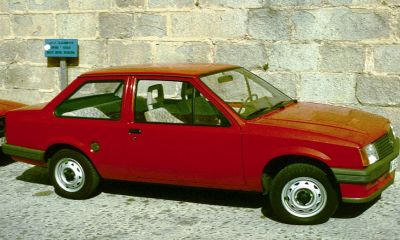 Red 2-door boxy sedan with steel wheels