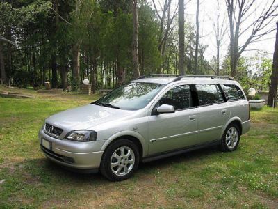 Silver station wagon with roof rails and alloy wheels parked on grass.