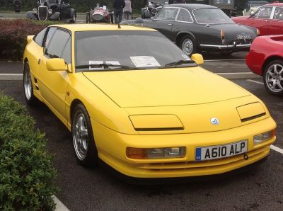 Yellow sports car with pop-up headlights and sleek aerodynamic coupe body.