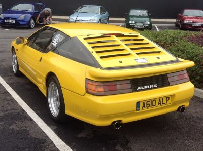 Rear view of yellow sports coupe with rear louvers and distinct taillights