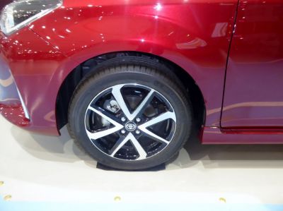 Close-up of alloy wheel with black and silver design on car.