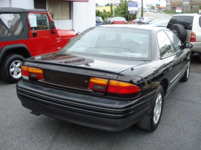 Rear view of black mid-90s sedan with classic tail lights