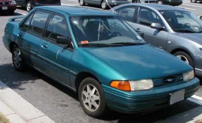 Four-door sedan, rectangular headlights, teal color