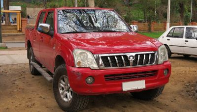 Red pickup truck with prominent grille and off-road tires