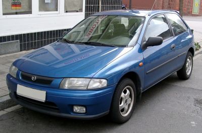 Compact blue hatchback front-side view with fog lights