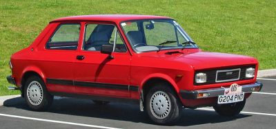 Red compact vintage car with boxy design and classic styling