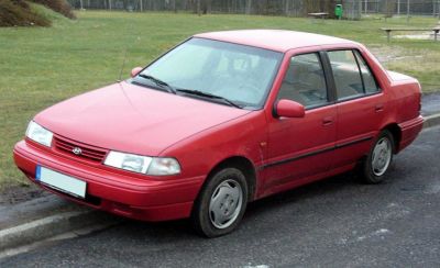 Red compact four-door sedan front three-quarter view