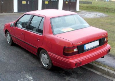 Rear profile of red vintage 4-door sedan with classic taillights and simple design