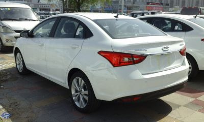 Rear and side view of white sedan with distinctive taillights.