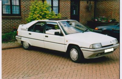 White four-door hatchback showing front and side profile with angular design.