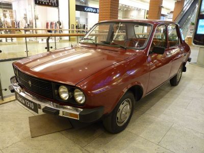 Front angled view with dual round headlights and vintage sedan body