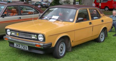 Yellow vintage sedan with unique roof and front grille details