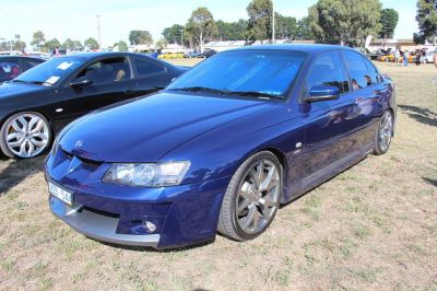 Blue sports sedan with front-side angle and alloy wheels.