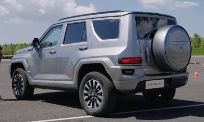 Rear and side view of a silver SUV with spare tire cover and angular design