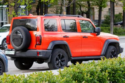 Orange off-road SUV with rear spare tire and black rims