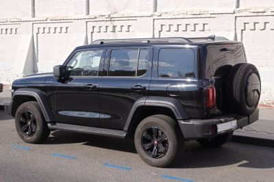 Black SUV side view with rear spare wheel and roof rails