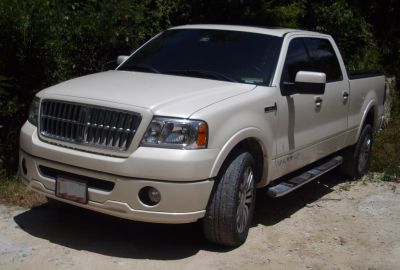 Front and side view of long bed pickup with prominent grille and crew cab