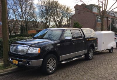Black Lincoln Mark LT facelift pickup truck with enclosed trailer from side view