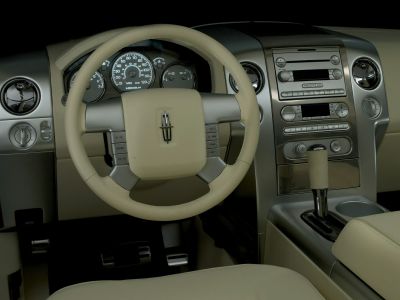 Steering wheel, dashboard, and gear shifter of a vehicle interior.