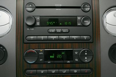 Radio and climate control panel with wood trim and digital displays