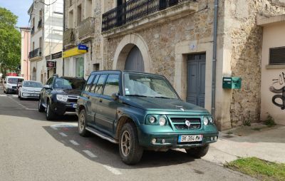 SUV with distinctive front grill and round headlights parked on street