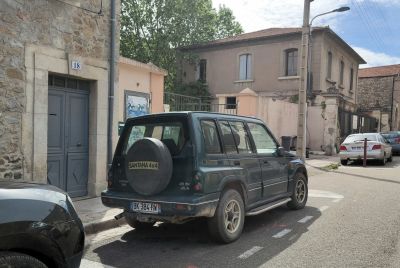 Boxy 4x4 SUV rear side with spare tire on tailgate and alloy wheels.
