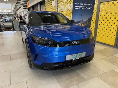 Front view of blue electric SUV with sleek headlights and aerodynamic grille