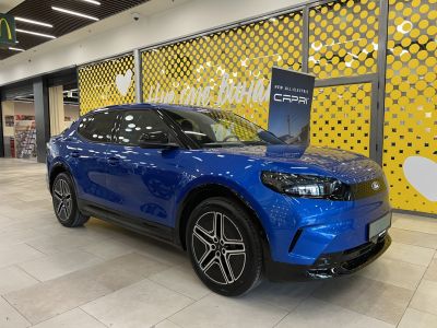 Blue all-electric compact SUV with aerodynamic front side design and modern headlight style.