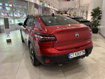 Rear view of a red vehicle with sleek taillights and dual exhaust