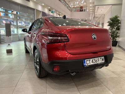 Red sedan rear with distinctive taillights and dual exhaust pipes