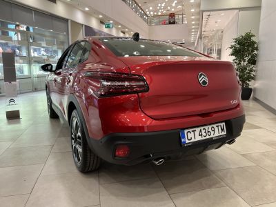 Rear view of a red hatchback with LED taillights and dual exhausts