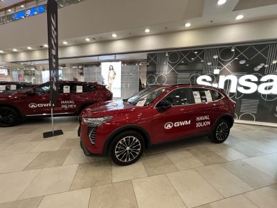 Front side view of a red SUV with alloy wheels in a showroom