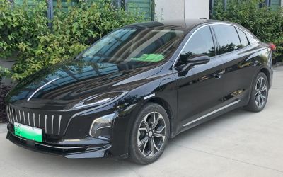 Front side view of a black electric sedan with LED headlights and distinctive grille