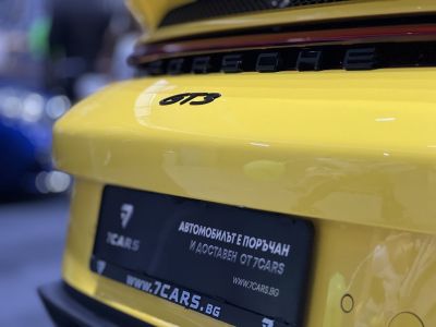 Close-up of yellow Porsche rear GT3 badge with license plate area