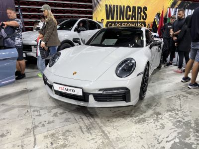 Front view of white sports coupe with round headlights and black trim