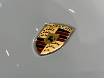 Close-up of a Porsche emblem on a light surface