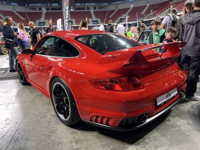 Red rear sports coupe with large wing spoiler and black wheels