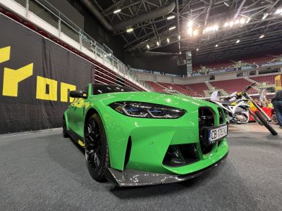 Aggressive green car front with sporty headlights and carbon fiber splitter