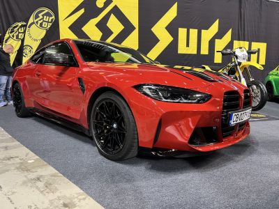 Red coupe with aggressive front grille and black sporty wheels