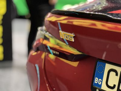 Close-up of a rear spoiler with NOS badge and license plate