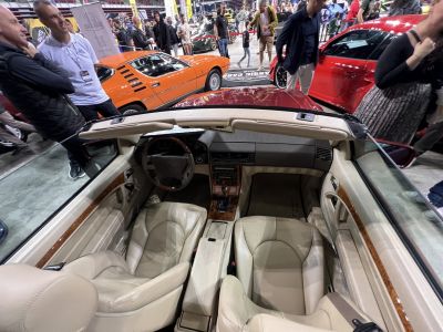 Beige leather convertible interior with wood trim and classic dashboard.