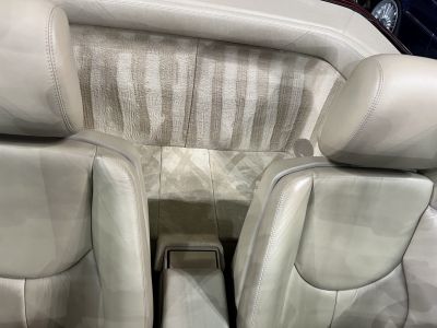 Close-up of beige leather seats and carpeted rear interior