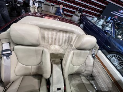 Beige leather convertible seats with wood trim and seat belts