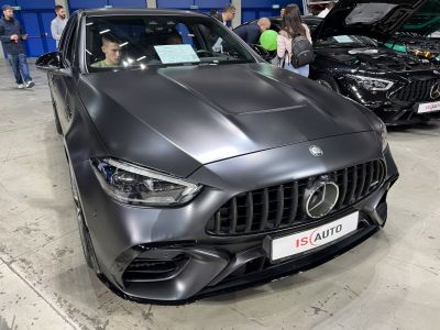 Aggressive front grille and sharp LED headlights of a matte black sport sedan.