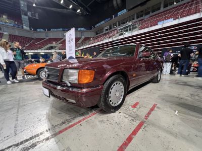Rectangular headlights and wide grille on a burgundy coupe with alloy wheels