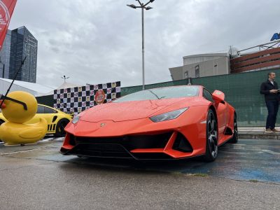 Front low-angle view of red-orange sports coupe with sleek headlights
